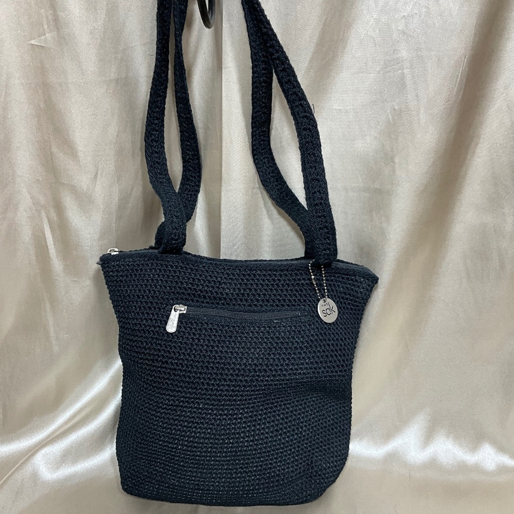 From “The SAK”’ a black hand made knit shoulder bag.     5-H5Db